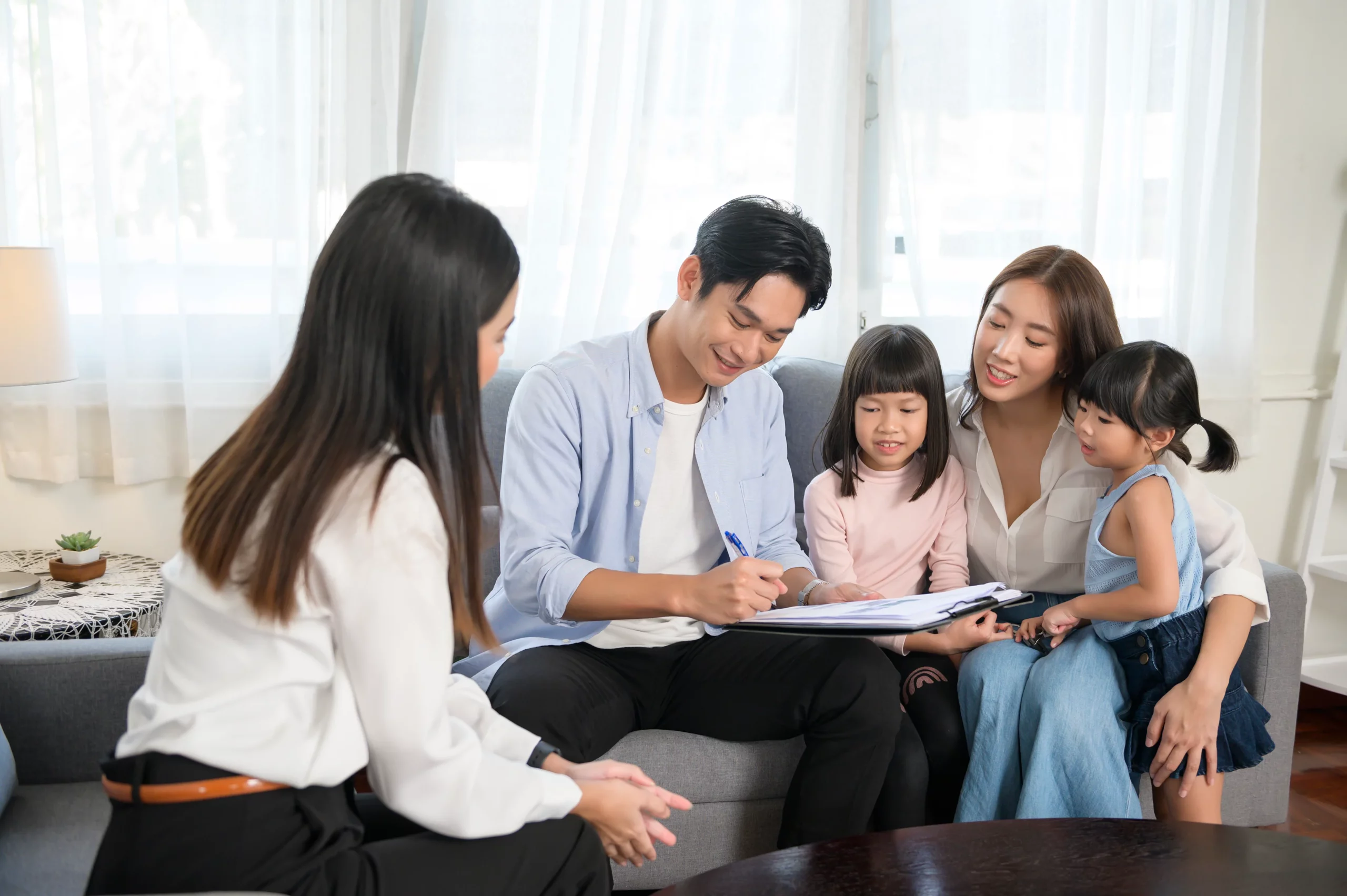 Family of four discussing estate planning paperwork on couch in bright home setting, representing how to contest a will in California and family involvement in legal challenges