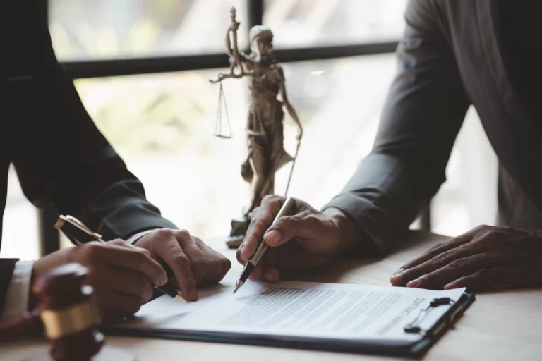 Attorney and client reviewing legal documents while gathering evidence of will or trust fraud in California