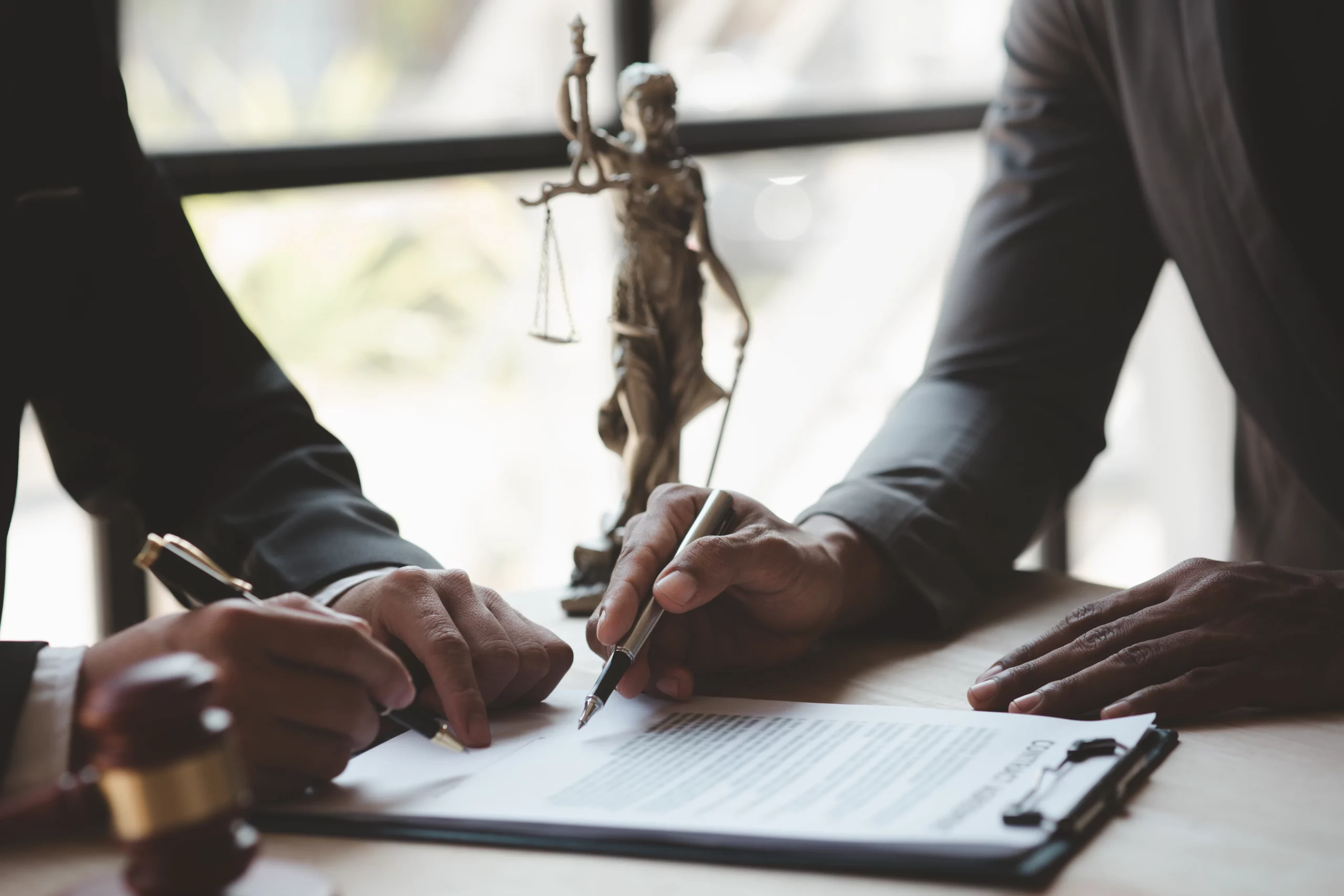 Attorney and client reviewing legal documents while gathering evidence of will or trust fraud in California