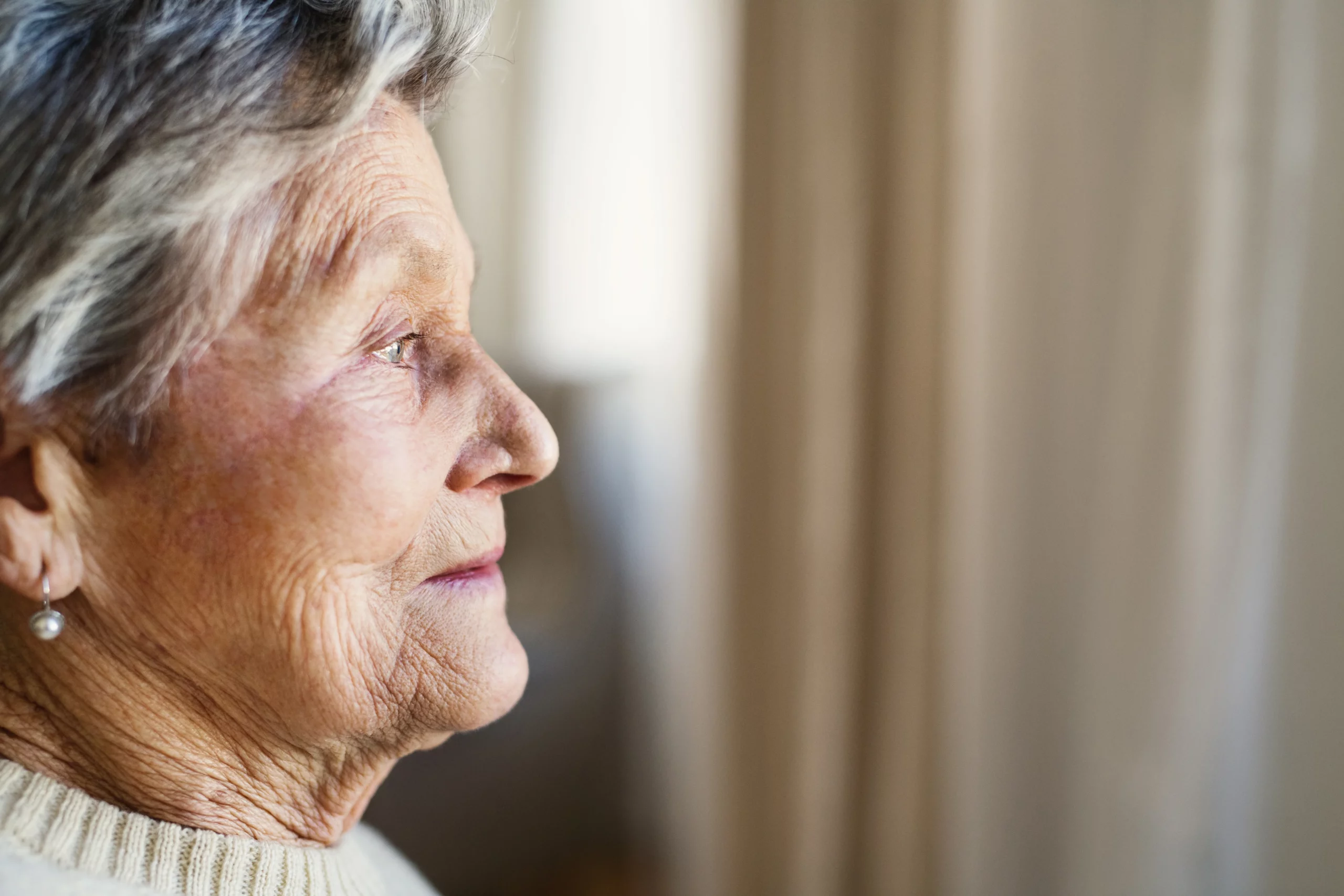 Elderly woman reflecting on last-minute trust amendment red flags in California